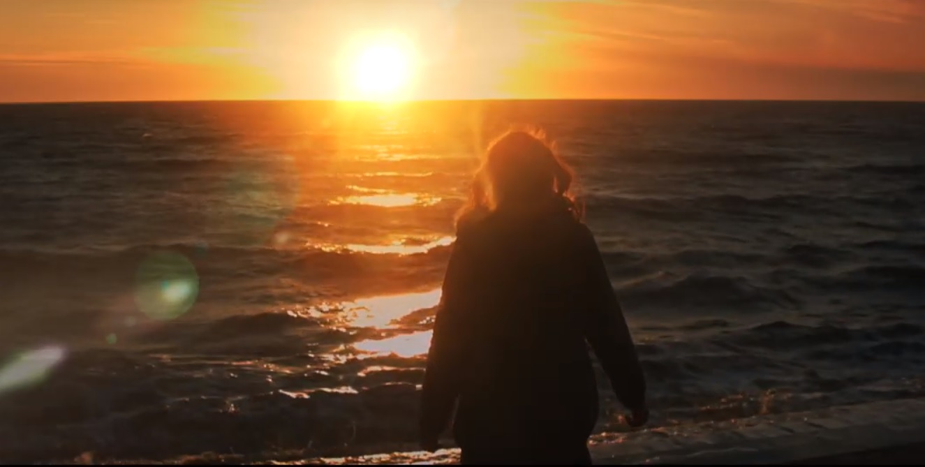 Woman in music video by the sea